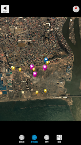 Satellite map of a riverfront city area with several colored markers (pink, yellow, blue) marking locations along the shore and streets, blue dot indicating current location.